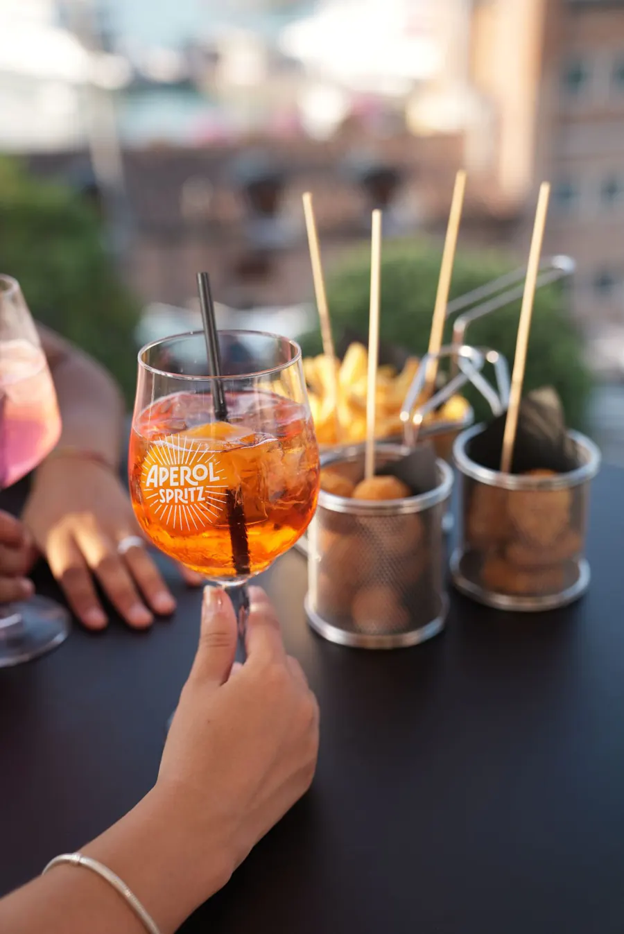 Spritz Aperol con mozzarelline e patatine fritte su un tavolo del Kiosko